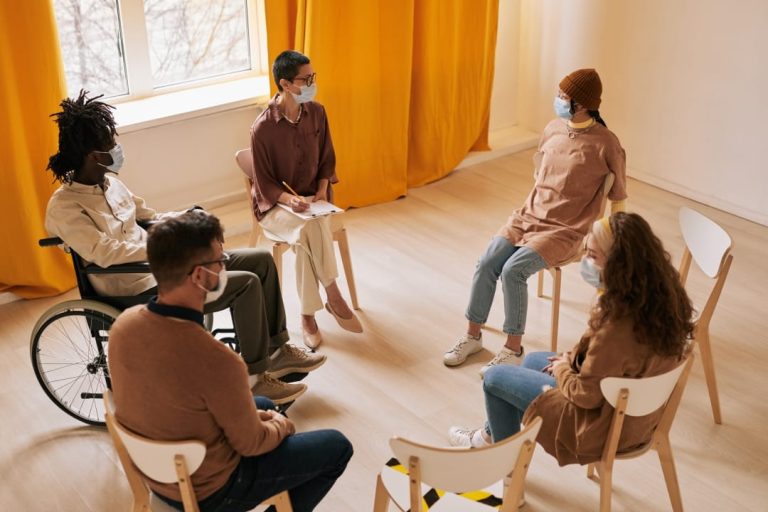 a group of people wearing face masks at group therapy