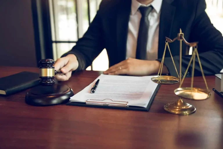 a person sitting at a desk with a gavel and a pen