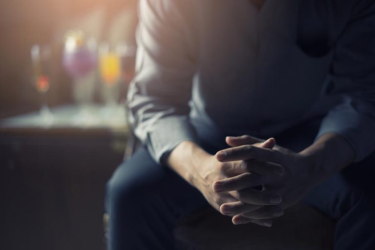 a person sitting down with their hands folded